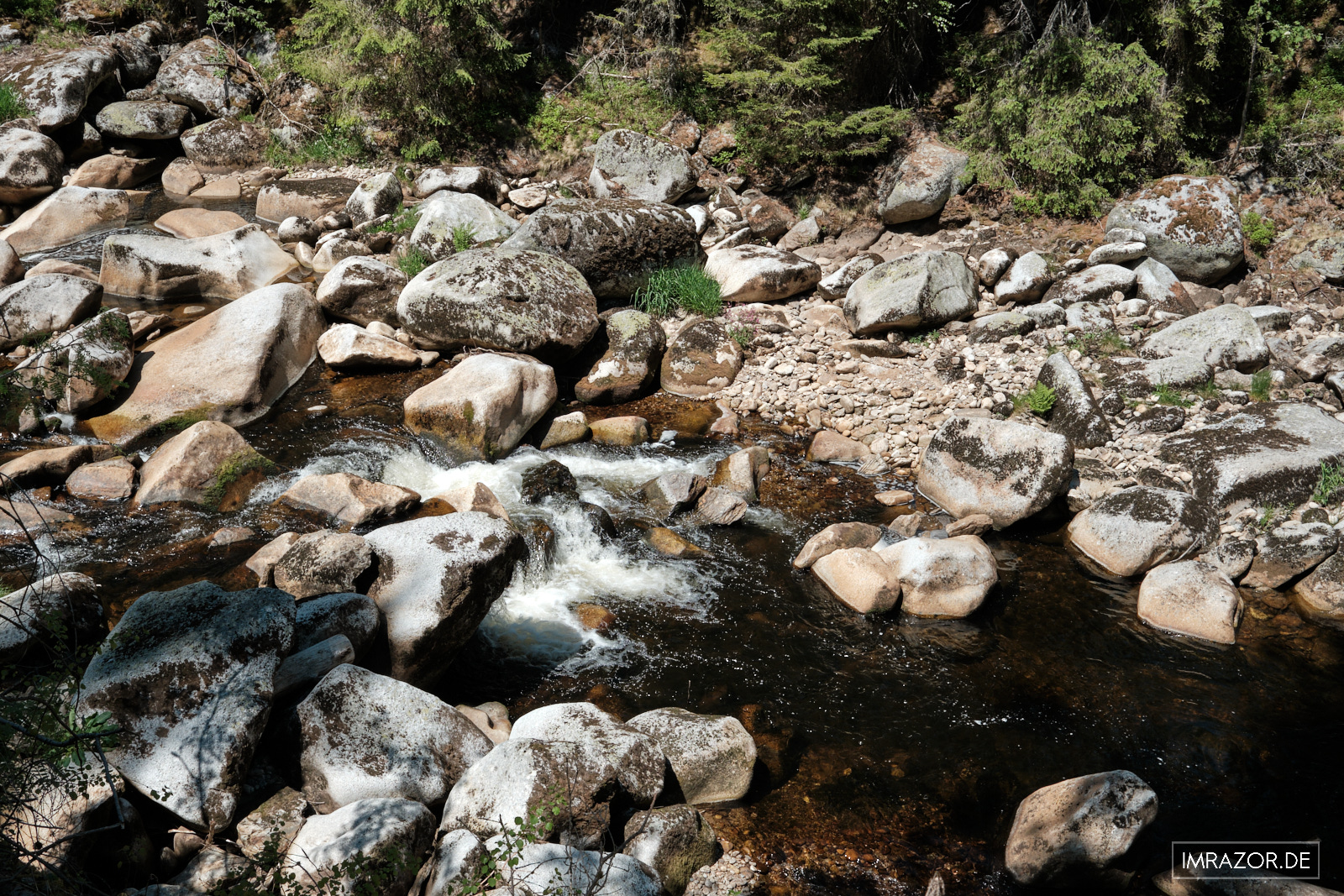 Große und kleine Steine im Flussbett von Wasser der Vydra umströmt